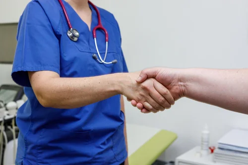 врач пожимает руку пациенту после лечения наркозависимости